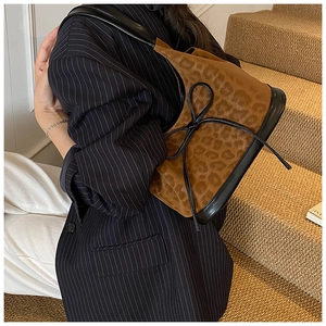 Detail of vintage leopard print handbag with black leather bow and suede texture