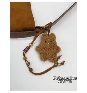 Detail of brown suede bucket bag with removable star charm and colorful boho beads