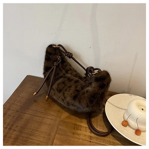 Détail du sac hobo en peluche léopard avec bandoulière en cuir noué et embouts dorés