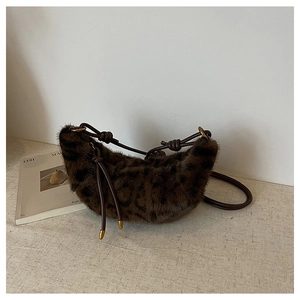 Détail du sac hobo en fausse fourrure léopard avec lanière en cuir et détails dorés
