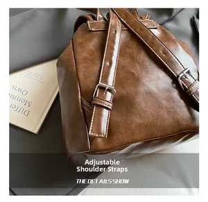 Detail of adjustable leather shoulder straps with metal buckles and contrast stitching