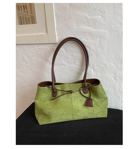 Dettaglio della borsa tote verde mela satinata con tracolla in pelle marrone e coulisse