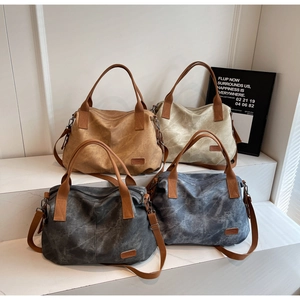 Detailed view of canvas tote bags in brown, beige, grey, and blue on white steps