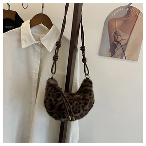 Détail du sac croissant en fausse fourrure léopard avec texture douce et bandoulière nouée