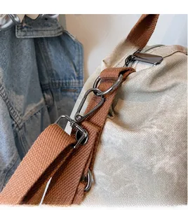 Macro shot of durable dark grey metal spring hook on a canvas tote bag with brown straps