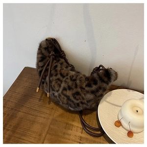 Détail du sac hobo en peluche léopard avec bandoulière en cuir et finitions dorées