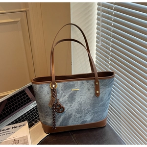 Detailed view of large marble pattern tote bag with leather trim and gold metal logo