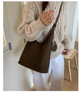 Detail of dark brown suede hobo bag with leather strap shown on model's shoulder