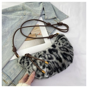 Détail du sac hobo en fausse fourrure léopard avec bandoulière brune et embouts dorés