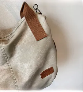 Detailed macro view of beige canvas texture with brown strap and leather brand label