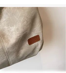 Detailed close-up of canvas texture and brown leather logo tag with precise stitching