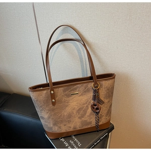 Detail of minimalist tote bag featuring marble texture fabric and brown leather straps