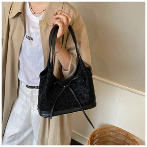 Close-up of black leopard print shoulder bag with suede texture and bow detail