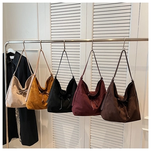 Close-up of drawstring tote bags in five colors hanging on a metal display rack