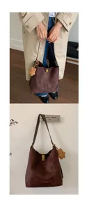 Detail of dark brown faux suede tote bag featuring a gold clasp and a cute plush bear charm