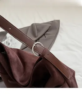 Macro detail of silver metal ring hardware on vintage brown suede shoulder bag strap