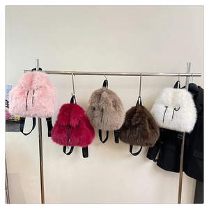 Detail of five faux fur backpacks in pink, burgundy, and beige with drawstring closures