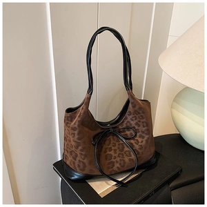 Detail of leopard print suede texture and black leather bow on retro shoulder bag