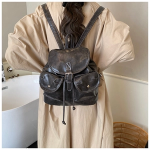 Detail of vintage drawstring backpack with contrast stitching and metallic gold studs