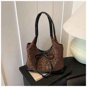 Detailed view of leopard print suede hobo bag with a delicate black leather bow accent