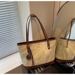 Detailed macro view of retro khali tote bag with dark brown leather trim and golden metal bar