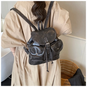 Detail of dark grey retro backpack showing vintage wax leather and white contrast stitching