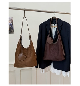 Detail of suede hobo bags in brown and tan with matching circular coin purse pendants