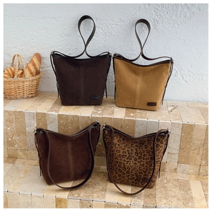 Vue détaillée de sacs cabas en daim à motif léopard et couleurs unies sur des marches