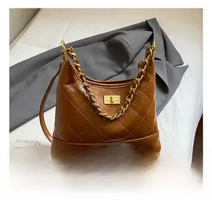 Détails de sac en cuir matelassé marron avec fermoir tournant doré et bandoulière chaîne