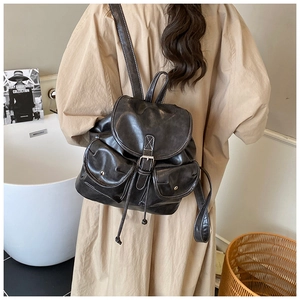 Detail view of large vintage backpack with white contrast stitching and dual front pockets