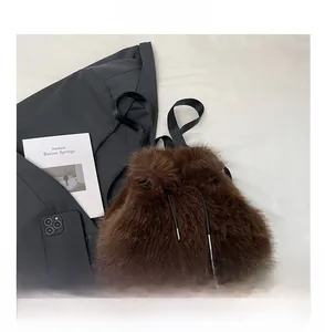 Detail of dark brown faux fur bucket bag with drawstring closure and nylon strap