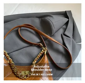 Détail de la bandoulière réglable et chaîne dorée sur sac vintage marron matelassé