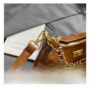 Détail d'un sac en cuir matelassé marron avec chaîne dorée et crochet métallique de qualité