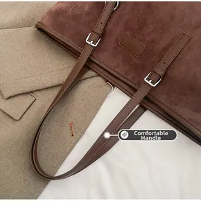 Detail of adjustable leather handle and matte texture on brown tote bag