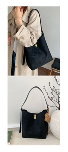 Detail of a black matte bucket bag featuring a gold turn-lock and cute plush bear charm