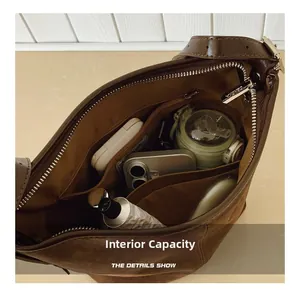 Vue intérieure d'un sac seau en daim marron montrant sa grande capacité et ses compartiments
