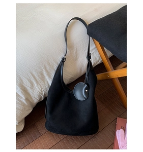 Detail view of black faux suede hobo bag with matching coin purse and slender strap