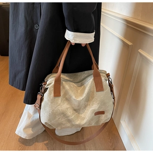 Detail of soft canvas texture and brown handles on the large crossbody tote bag