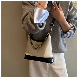 Détail du sac matelassé vintage en cuir beige et noir avec fermoir doré