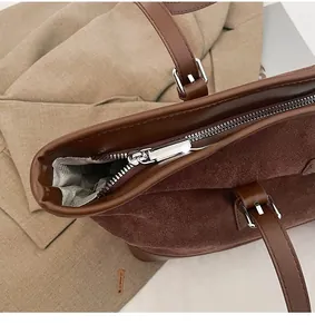 Close-up of smooth metal zipper and premium suede texture on leopard tote bag