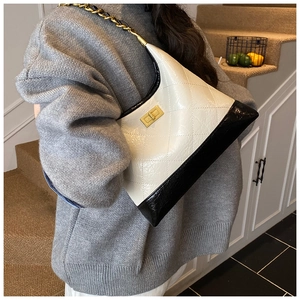 Détails des surpiqûres en losange et de la bandoulière en chaîne de ce sac hobo chic