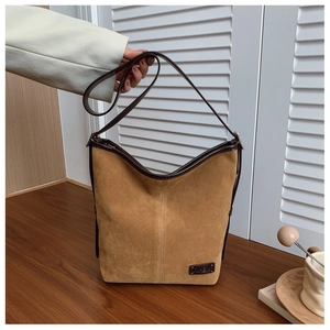Détail du sac seau en daim léopard marron avec poignée et finitions en cuir élégantes