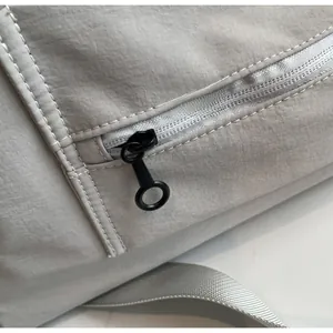 Detail shot of the smooth gray zipper with black round puller on a travel bag
