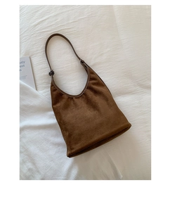 Detail of dark brown suede hobo bag with smooth matte texture and leather strap