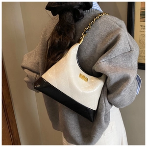 Détail du motif matelassé et du fermoir doré sur le sac hobo bicolore noir et blanc