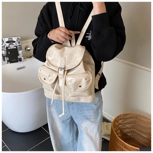 Detailed view of beige faux leather backpack with drawstring and adjustable straps