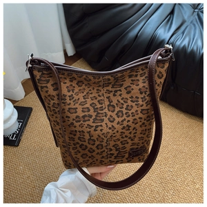 Détail d'un sac en toile imprimé léopard avec bandoulière en cuir et étiquette