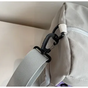 Close-up of durable swivel hook and reinforced nylon strap on gray travel bag
