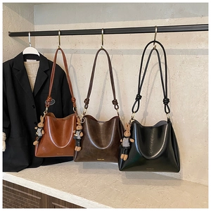 Detail of vintage bucket bags in brown and black with cute rabbit charm pendants