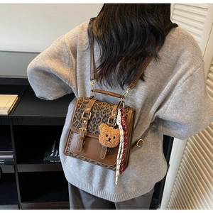Detail of the leopard print flap and PU leather stitching on a retro backpack with bear charm